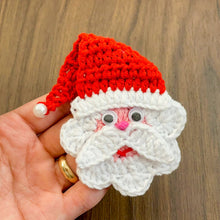 Handmade crochet Santa Claus applique with a red hat and white beard, featuring googly eyes. Perfect for Christmas decorations or as a festive ornament.