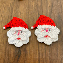 Handmade crochet Santa Claus applique with a red hat and white beard, featuring googly eyes. Perfect for Christmas decorations or as a festive ornament.