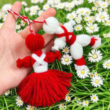 Traditional Bulgarian Martenitsa yarn dolls, Pizho and Penda, made from red and white yarn for Baba Marta Day celebrations.