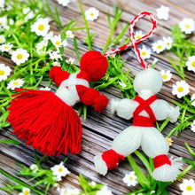 Traditional Bulgarian Martenitsa yarn dolls, Pizho and Penda, made from red and white yarn for Baba Marta Day celebrations.