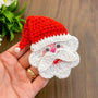 Handmade crochet Santa Claus applique with a red hat and white beard, featuring googly eyes. Perfect for Christmas decorations or as a festive ornament.