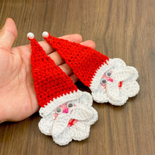 Handmade crochet Santa Claus applique with a red hat and white beard, featuring googly eyes. Perfect for Christmas decorations or as a festive ornament.