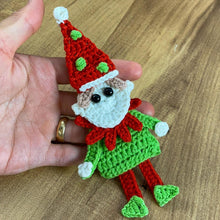 Handmade crochet Christmas elf ornament in red and green with festive hat and detailed face, perfect for holiday decor and DIY Christmas crafts.