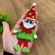 Handmade crochet Christmas elf ornament in red and green with festive hat and detailed face, perfect for holiday decor and DIY Christmas crafts.