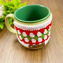 Handmade red, green, and white crochet mug cozy, Christmas-themed decorative cup cover, festive crochet cup sleeve for keeping drinks warm.