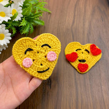 Handmade crochet heart motif featuring a large yellow base adorned with small red hearts, perfect for adding a touch of warmth and love to any craft project