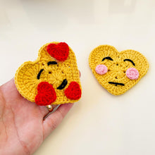 Handmade crochet heart motif featuring a large yellow base adorned with small red hearts, perfect for adding a touch of warmth and love to any craft project