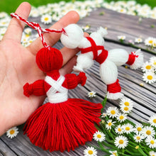 Traditional Bulgarian Martenitsa yarn dolls, Pizho and Penda, made from red and white yarn for Baba Marta Day celebrations.