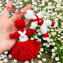 Traditional Bulgarian Martenitsa yarn dolls, Pizho and Penda, made from red and white yarn for Baba Marta Day celebrations.
