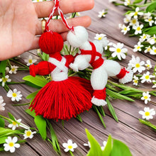 Traditional Bulgarian Martenitsa yarn dolls, Pizho and Penda, made from red and white yarn for Baba Marta Day celebrations.