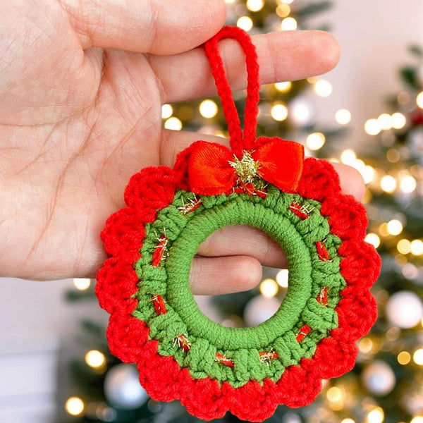 Handmade crochet Christmas wreath ornament with red and green design and decorative bow