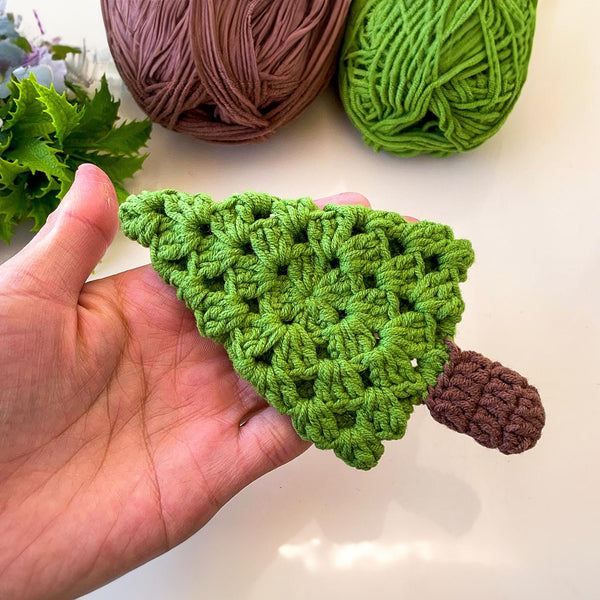 A handmade crochet pine tree keychain with a vibrant green top and a textured brown trunk, designed as a cute and eco-friendly accessory. Perfect for use as a keychain, bag charm, or small Christmas tree ornament.