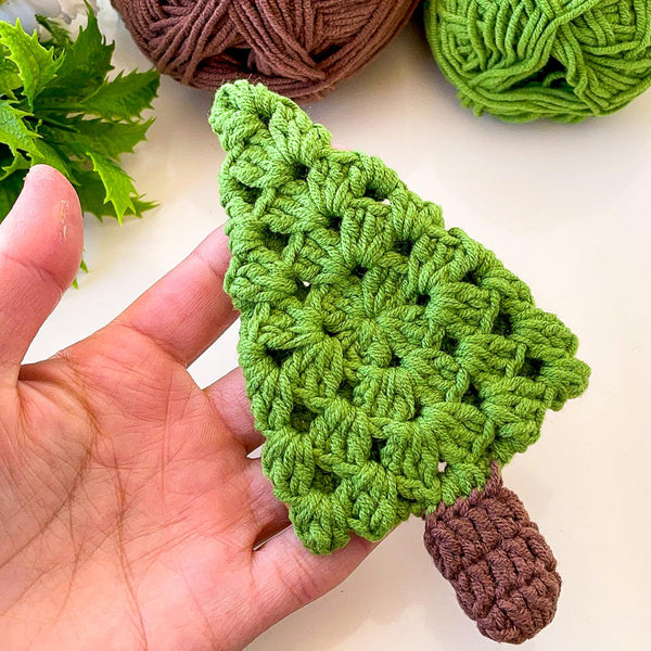 A handmade crochet pine tree keychain with a vibrant green top and a textured brown trunk, designed as a cute and eco-friendly accessory. Perfect for use as a keychain, bag charm, or small Christmas tree ornament.