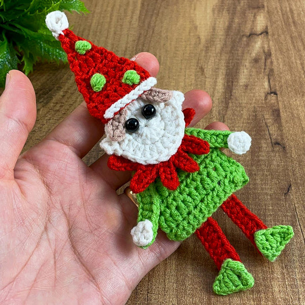 Handmade crochet Christmas elf ornament in red and green with festive hat and detailed face, perfect for holiday decor and DIY Christmas crafts.