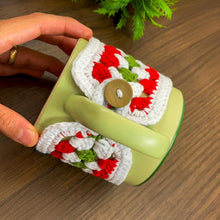 Handmade red, green, and white crochet mug cozy, Christmas-themed decorative cup cover, festive crochet cup sleeve for keeping drinks warm.